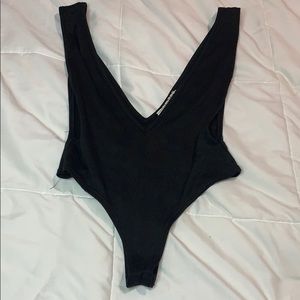 Very low cut black sling bodysuit